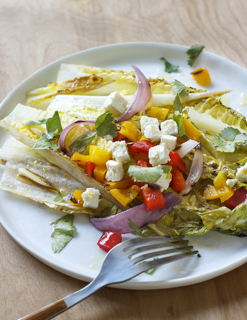 Grilled Salad with Romaine, Peppers, Feta, and Cilantro / JillHough.com The slightly bitter nature of romaine is nicely complemented by a little charring, and the same is true for endive and radicchio. You can change things up by using one or both of those instead of some or all of the romaine, and also by using different cheeses and herbs. #salad #grilling #grilledsalad #romaine #feta #peppers #cilantro #grilledpeppers