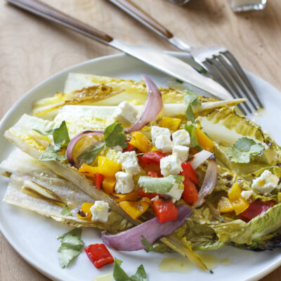 Grilled Salad with Romaine, Peppers, Feta, and Cilantro / JillHough.com The slightly bitter nature of romaine is nicely complemented by a little charring, and the same is true for endive and radicchio. You can change things up by using one or both of those instead of some or all of the romaine, and also by using different cheeses and herbs. #salad #grilling #grilledsalad #romaine #feta #peppers #cilantro #grilledpeppers