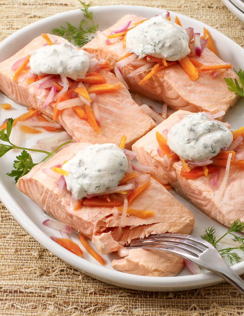 Dill-Poached Salmon with Herbed Yogurt Sauce / JillHough.com Delicate poaching lets the rich, clean flavors of a great piece of salmon shine. Poaching also helps ensure it cooks up juicy and tender. #salmon #poachedsalmon #yogurt #yogurtsauce #herbs #parsley #dill