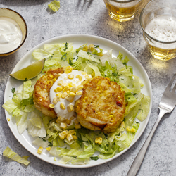 Corn and Crab Cakes with Cilantro and Lime Sour Cream / JillHough.com Corn—both in the cakes and as a garnish—along with cilantro, lettuce, and lime, gives this classic a slight Tex-Mex spin. On the side, serve tortilla chips to scoop up every mouthful. #corn #crabcakes #cilantro #lime #cornandcrab #corncakes