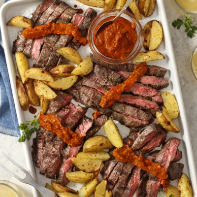 Grilled Skirt Steak and Potatoes with Romesco / JillHough.com A version of this dish—featuring romesco, a smoky, silky, seductive Spanish red pepper sauce—is part of my regular repertoire. Sometimes I do it with salmon instead of steak, and sometimes I roast or pan-sear instead of grilling. But I always use a forkful of potato to wipe up every last bit of the addictive sauce. #skirtsteak #steak #potatoes #steakandpotatoes #meatandpotatoes #romesco #romescosauce #Spanishfood