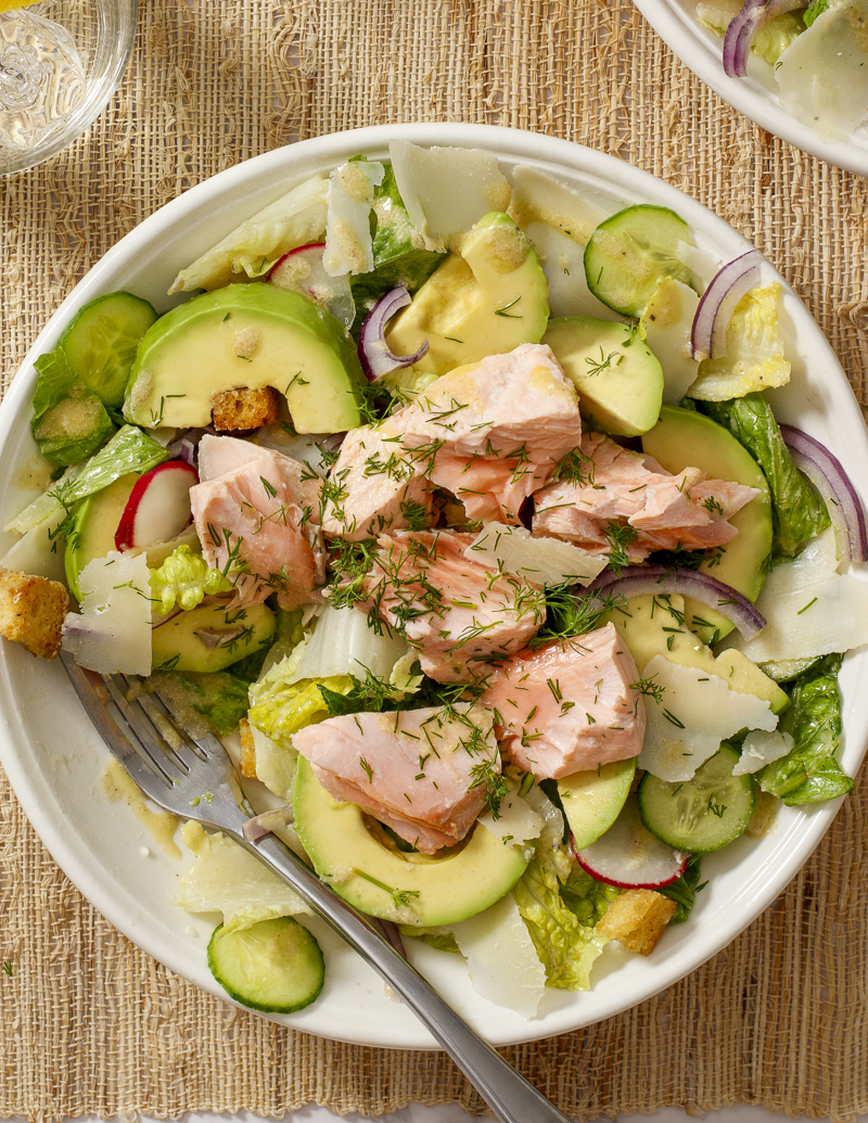 Salmon and Avocado Caesar Salad / JillHough.com A classic Caesar embellished with hunks of salmon and avocado, plus cucumber, radishes, and onion. It ticks all the boxes and more. #salmon #caesar #caesarsalad #avocado #dinnersalad #mealsalad #fish #fishandseafood #ceasarsalad #ceasar