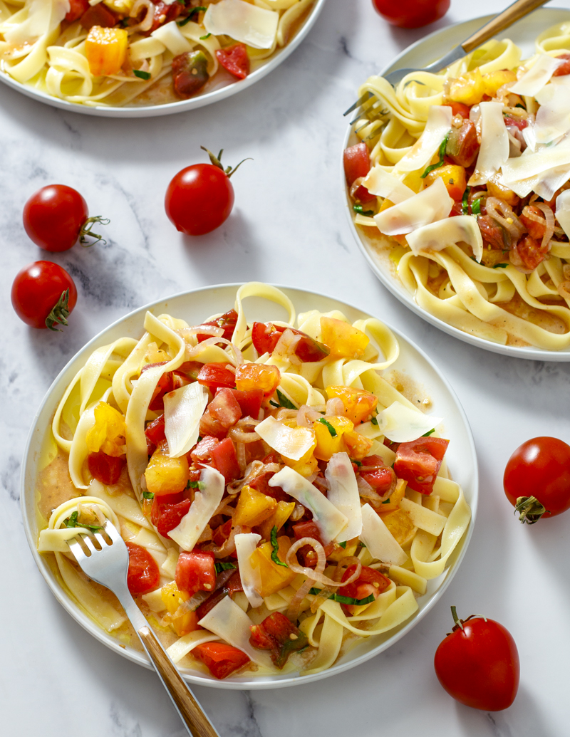 Tons of Tomatoes Fettuccine / JillHough.com This beautifully simple pasta—with tons of tomatoes, shallots, basil, parmesan, and olive oil—is a celebration of peak-season tomatoes. #tomatoes #tomatopasta #freshtomatopasta #summerpasta #summertomatoes #basil #shallots #parmesan #fettuccine #tomatofettuccine